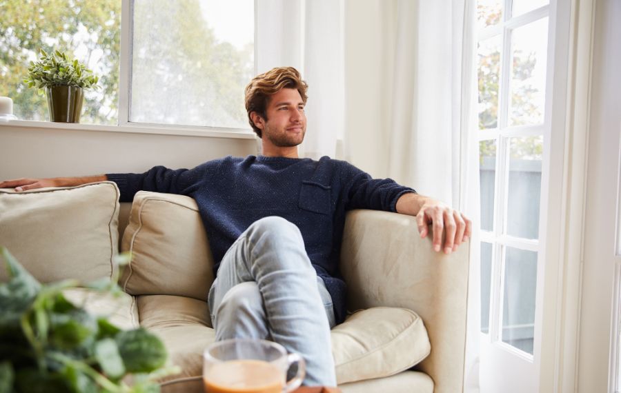 Astuces déco anti-anxiété » 5 Astuces Déco Anti-Anxiété Pour Transformer Votre Espace en 2025 Personne détendue dans un intérieur lumineux et apaisant, illustrant le concept d'astuces déco anti-anxiété